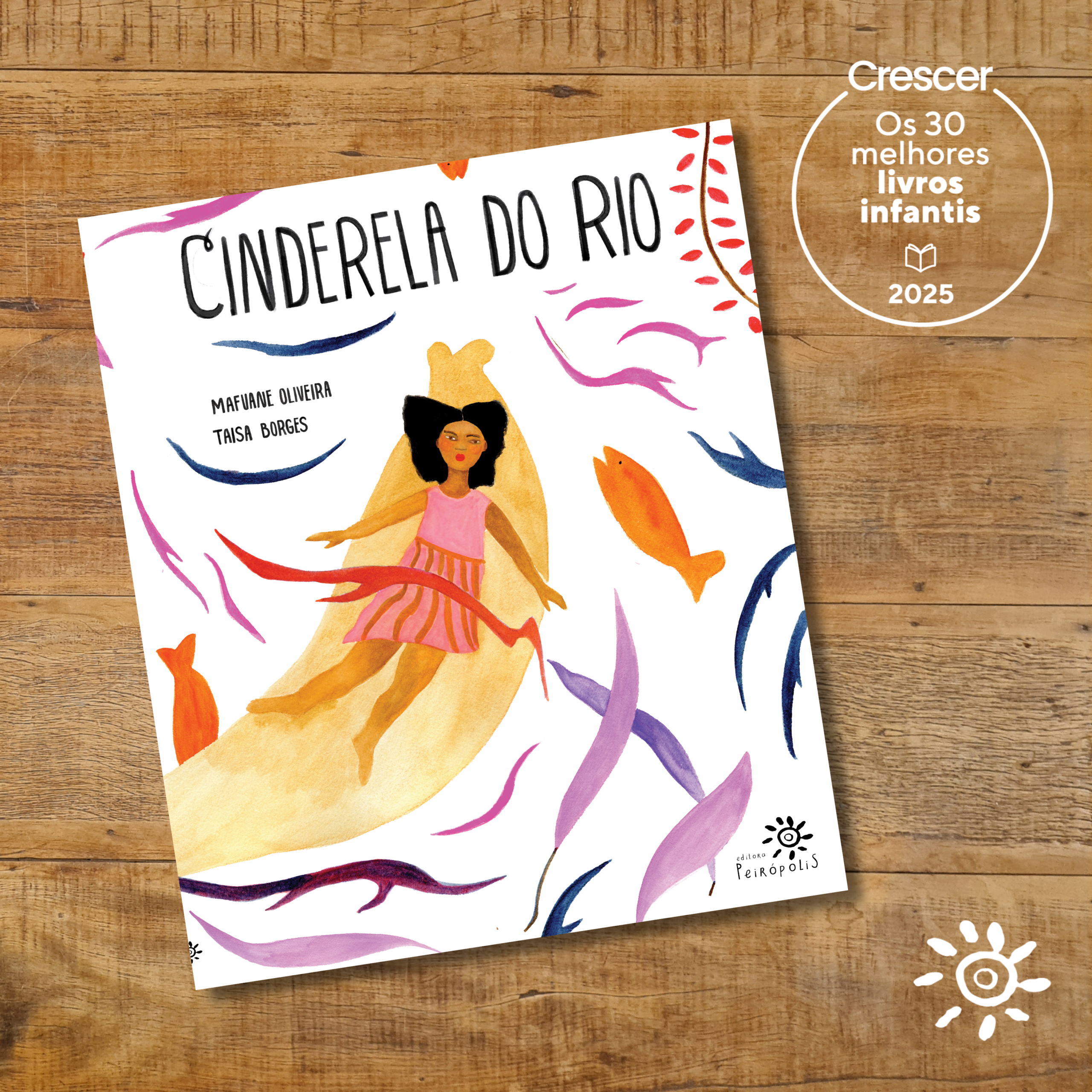 Capa do livro Cinderela do Rio, de Mafune Oliveira com ilustrações de Taisa Borges. A ilustração mostra uma menina negra de vestido rosa e cabelos soltos deslizando dentro de uma canoa dourada, rodeada por peixes coloridos e plantas aquáticas em tons de roxo, laranja e azul sobre fundo branco. O livro aparece sobre uma superfície de madeira. No canto superior direito, há um selo circular da revista Crescer indicando: “Os 30 melhores livros infantis – 2025”. No canto inferior direito, está o logotipo da Editora Peirópolis.